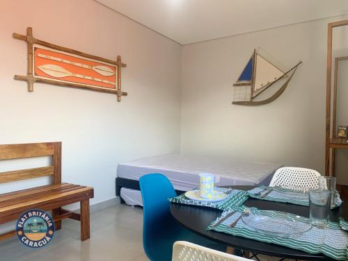 a room with a table and a bed and a table and chairs at Lindo Flat com Ar Perto do Mar in Caraguatatuba