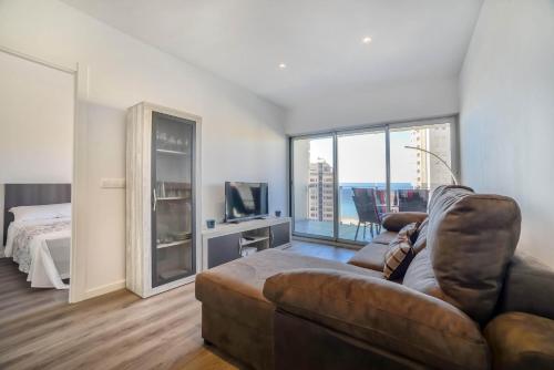 a living room with a couch and a television and a bed at Apartamento Mirador - PlusHolidays in Calpe