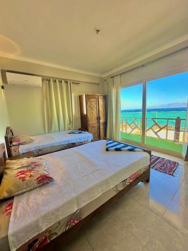 two beds in a bedroom with a view of the ocean at Moon house n.30 in Dahab