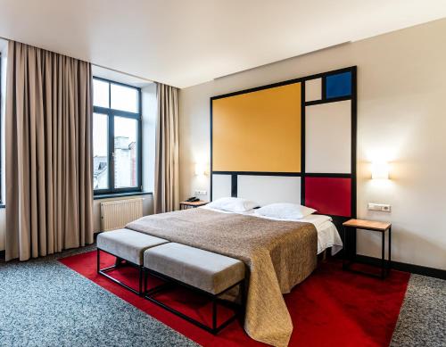 ein Hotelzimmer mit einem Bett und zwei Fenstern in der Unterkunft VICTORIA Hotel Kaunas in Kaunas