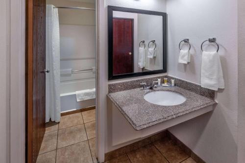 a bathroom with a sink and a mirror at Super 8 by Wyndham Clayton in Clayton