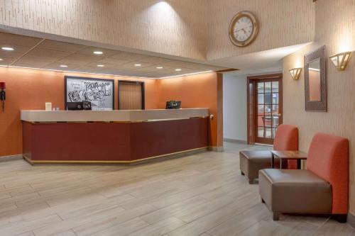 a waiting room with a reception desk and a clock at Super 8 by Wyndham Wausau in Wausau
