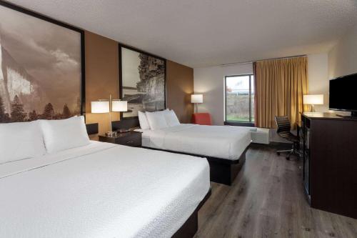 a hotel room with two beds and a flat screen tv at Super 8 by Wyndham Wausau in Wausau
