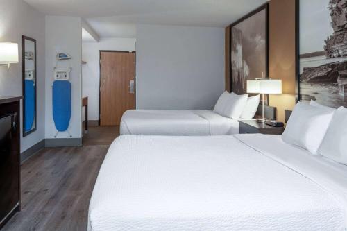 a hotel room with two beds and a bathroom at Super 8 by Wyndham Wausau in Wausau