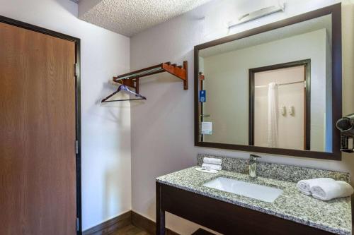 a bathroom with a sink and a mirror at Super 8 by Wyndham Wausau in Wausau