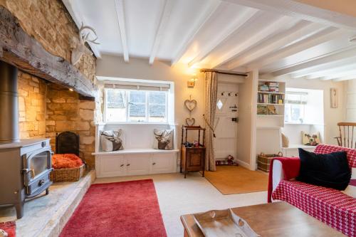 a living room with a couch and a fireplace at Red Lion Cottage in Blockley
