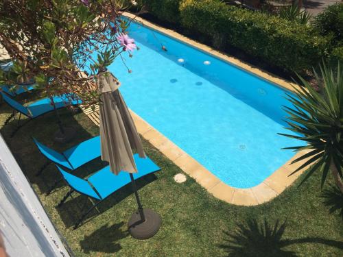 een parasol en een stoel naast een zwembad bij Only Women Guest House - Villa de la Comunidad Internacional de la Mujer in Olivella