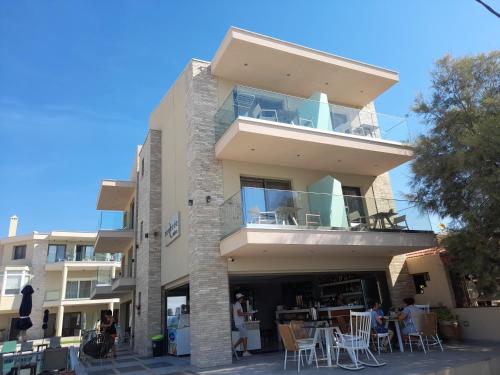 a tall building with tables and chairs in front of it at Reverie in Limenaria