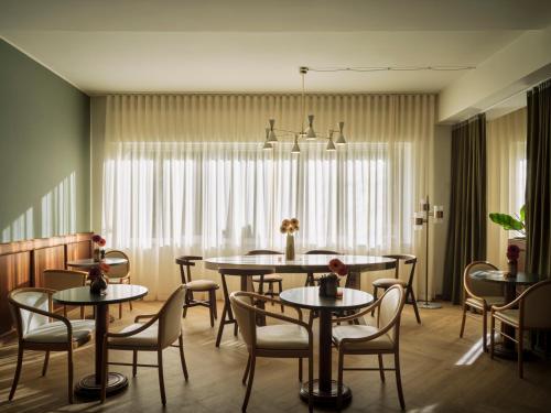 a dining room with tables and chairs at Max Brown Hotel Missori, part of Sircle Collection in Milan