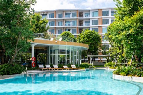 un hotel con piscina frente a un edificio en Phyll Phuket 2 BR apartment near Central Festival by NLA, en Phuket