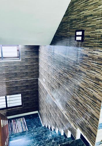 baño con una gran pared de ladrillo y ducha en Puthookkadans Mareena Lodge en Kottayam