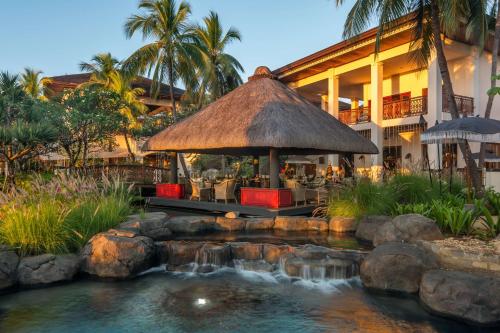 a resort with a pond in front of a building at Hilton Mauritius Resort & Spa in Flic-en-Flac