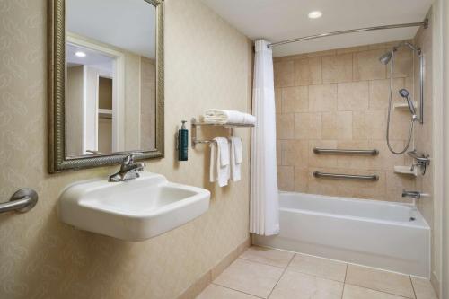 a bathroom with a sink and a tub and a shower at DoubleTree by Hilton Rocky Mount in Rocky Mount
