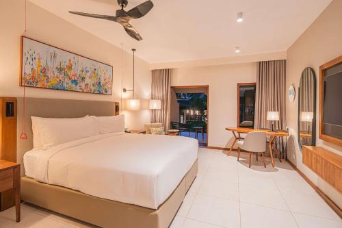 a bedroom with a large bed and a dining room at Hilton Mauritius Resort & Spa in Flic-en-Flac