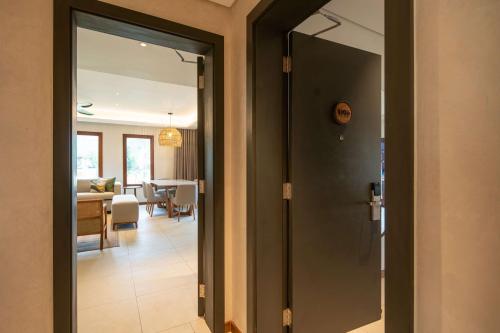 a door leading into a living room with a dining room at Hilton Mauritius Resort & Spa in Flic-en-Flac
