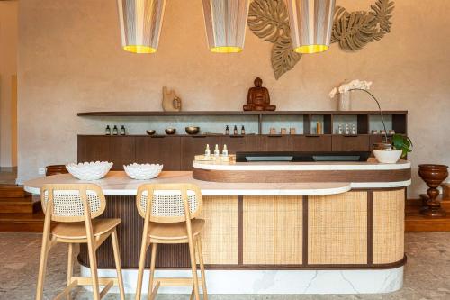 a kitchen with a bar with chairs and a table at Hilton Mauritius Resort & Spa in Flic-en-Flac