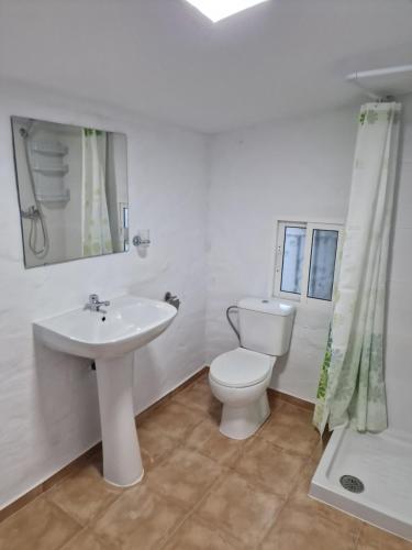 Baño blanco con aseo y lavamanos en Alora Sweet Home en Alora