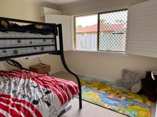 a bedroom with a bunk bed and a window at Gardens by the Bay - Acreage Living & EV Charging in Deception Bay