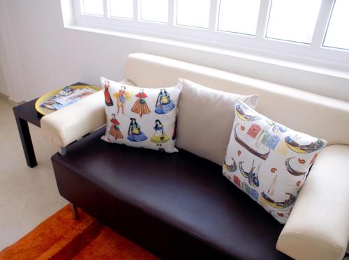 a white couch with pillows on it in a room at Taah Billa Guest House in Tavira
