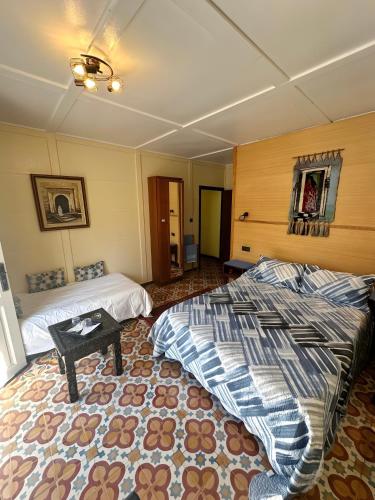 a bedroom with two beds and a table in it at Les IRIS in Al Hoceïma