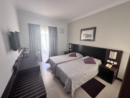 a hotel room with a bed and a television at Grand Harbour Hotel in Valletta