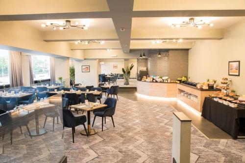 a restaurant with tables and chairs and a counter at Park Inn by Radisson Bournemouth in Bournemouth