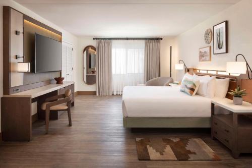 a hotel room with a large bed and a desk at The Scottsdale Resort & Spa, Curio Collection by Hilton in Scottsdale