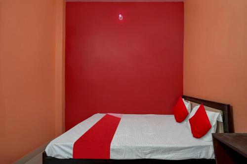 a red bedroom with a bed with two red pillows at OYO Flagship Hotel R.M in Patna