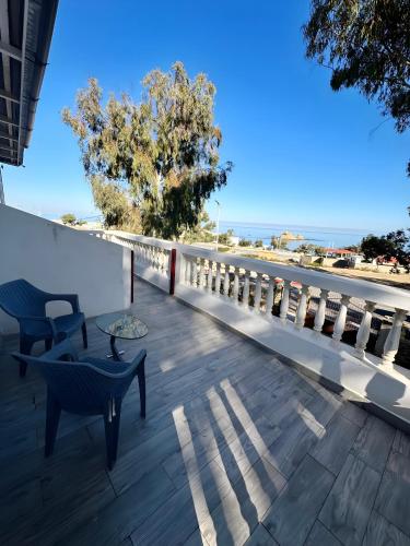 a balcony with a table and chairs and a view of the ocean at Les IRIS in Al Hoceïma