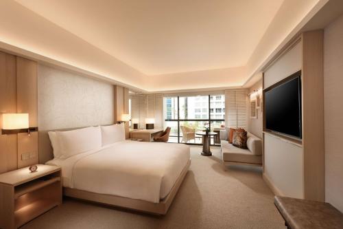a hotel room with a bed and a television at Conrad Singapore Orchard in Singapore