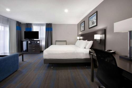 a hotel room with a bed and a flat screen tv at Days Inn by Wyndham Barrie in Barrie