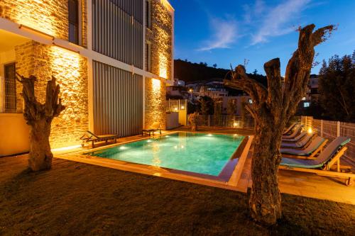 a villa with a swimming pool at night at Güllük Elegance Otel in Gulluk