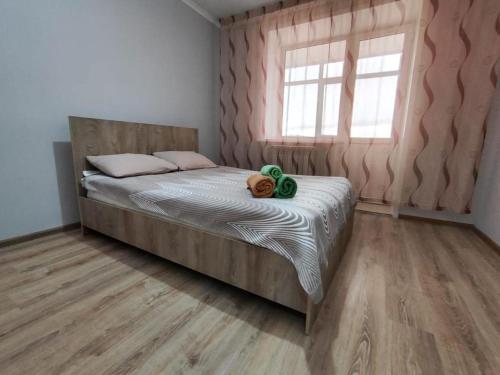 a bedroom with a bed with a teddy bear on it at Квартира посуточно in Kokshetau