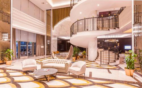 a lobby of a hotel with a spiral staircase at Hilton Samarkand Regency in Samarkand