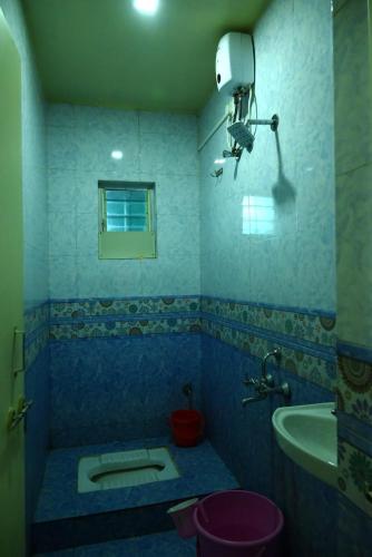 a blue bathroom with a toilet and a sink at P P Lodging in Pune