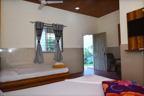 a bedroom with two beds and a large window at P P Lodging in Pune