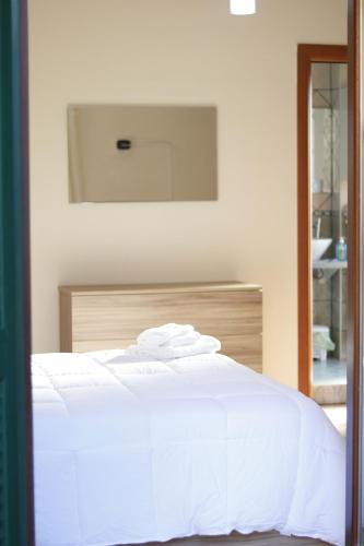 a bedroom with a white bed and a mirror at CASA HYRIA in Nola