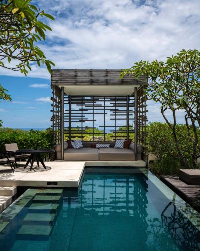 a villa with a swimming pool and a bed and a table at Alila Villas Uluwatu in Uluwatu