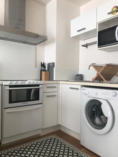une cuisine blanche avec un lave-linge et un lave-linge dans l'établissement Appartement Perpignan, à Perpignan