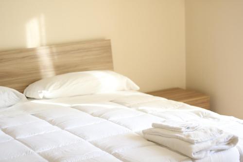 a white bed with two folded towels on it at CASA HYRIA in Nola