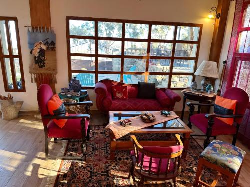 a living room with a red couch and chairs at Les IRIS in Al Hoceïma