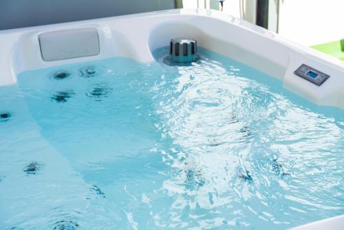 a bath tub filled with blue water with a faucet at MEDANO4YOU Surfers Cove Holiday Home in El Médano