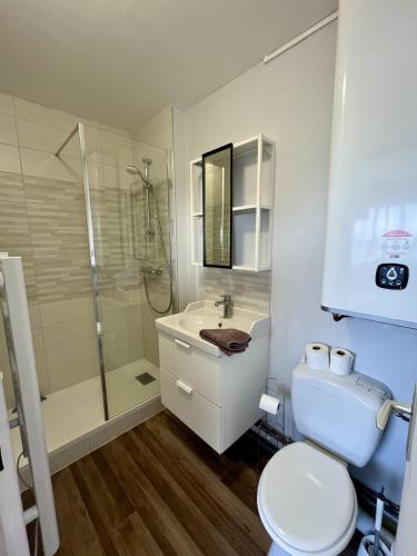 a bathroom with a toilet and a shower and a sink at Appartement au pied de la plage - Balcon - Parking in Courseulles-sur-Mer