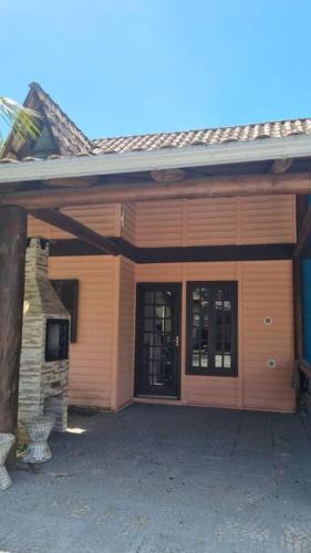 una casa con una porta in legno e un edificio di Chalé Carvalho - Salmão a Itapoa