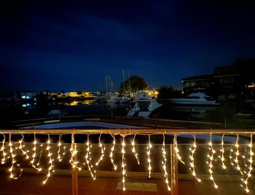 a string of lights on a dock at night at BLAU Apartamento frente a los canales y las puestas de sol de Roses in Roses