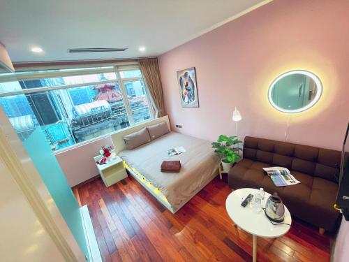 una pequeña sala de estar con sofá y ventana en MAY - TRENDY SKY VIEW - Phone 09756-59323, en Hanói
