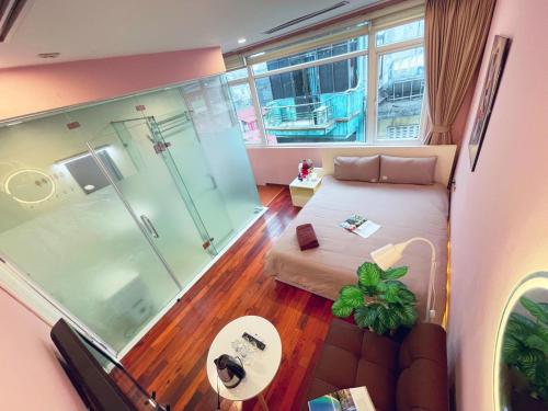 Habitación con ducha, cama y puerta de cristal en MAY - TRENDY SKY VIEW - Phone 09756-59323, en Hanói