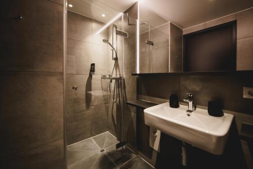 a bathroom with a sink and a shower at NUNA – nachhaltig schlafen in Rosenheim