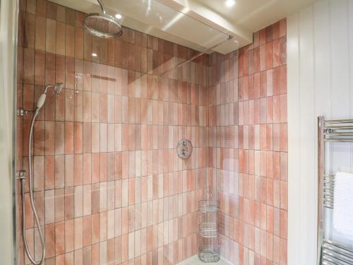 a bathroom with a shower with brown tiles at Dant Y Llew in Bow Street
