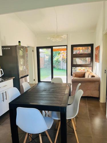 a kitchen with a dining table and white chairs at Twin House #1 in David